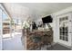 Covered outdoor bar area, equipped with a TV, seating, and lush greenery at 3244 Amaca Cir, Orlando, FL 32837