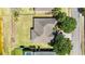 Aerial view of home with modern roof, lush lawn, mature trees, and waterfront access at 330 Osprey Lakes Cir, Chuluota, FL 32766