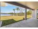 Expansive backyard featuring lush greenery, serene lake view, and swaying palm trees under a sunny sky at 330 Osprey Lakes Cir, Chuluota, FL 32766