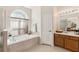 Relaxing bathroom with a garden tub under a large window and a separate glass enclosed shower at 330 Osprey Lakes Cir, Chuluota, FL 32766