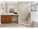 Bathroom features a shower with glass door, vanity with storage, and decorative lighting at 330 Osprey Lakes Cir, Chuluota, FL 32766