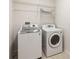 Bright laundry room featuring modern appliances and convenient overhead storage shelves at 330 Osprey Lakes Cir, Chuluota, FL 32766