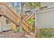 Exterior view of a building with a wooden staircase surrounded by landscaping, offering easy access at 336 Scottsdale Sq # 336, Winter Park, FL 32792