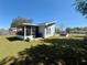 View of the back exterior with a screened in porch and fenced yard at 38 Juniper Pass Dr, Ocala, FL 34480