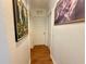 Hallway view showcasing multiple doors, two art pieces and laminate floors at 38 Juniper Pass Dr, Ocala, FL 34480