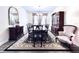 Formal dining room with elegant dark wood furniture, a decorative rug, and neutral walls at 4562 Tribute Trl, Kissimmee, FL 34746
