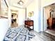 Bright and inviting foyer with wood-look tile floors, a stylish rug, and a decorative table at 4562 Tribute Trl, Kissimmee, FL 34746