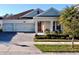 Charming single-story home with a two-car garage, brick-paved driveway, and nicely landscaped front yard at 4562 Tribute Trl, Kissimmee, FL 34746