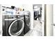 Functional laundry room equipped with modern black washer and dryer, plus ample storage, and access to closet at 4562 Tribute Trl, Kissimmee, FL 34746