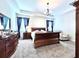 Inviting main bedroom featuring a dark wood bed set, neutral carpet, curtains and ample natural light at 4562 Tribute Trl, Kissimmee, FL 34746