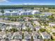 An aerial shot presents community living with lake views, condos, white houses, and amenities under a sunny sky at 4704 Sleepy Hollow Dr, Kissimmee, FL 34746
