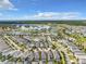 A broad aerial perspective of a community featuring homes, apartments, a lake, and recreational spaces under a vibrant sky at 4704 Sleepy Hollow Dr, Kissimmee, FL 34746