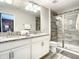Bathroom with double vanity, granite countertops, tile flooring, and modern shower with glass door at 4704 Sleepy Hollow Dr, Kissimmee, FL 34746