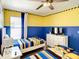 Bright ' bedroom with twin beds, a minion theme, and a vibrant yellow and blue color scheme at 4704 Sleepy Hollow Dr, Kissimmee, FL 34746