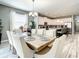 Bright dining room with a large wooden table, white upholstered chairs, and an elegant chandelier at 4704 Sleepy Hollow Dr, Kissimmee, FL 34746