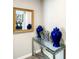 Hallway featuring mirror, glass table with decorative items, and neutral wall color at 4704 Sleepy Hollow Dr, Kissimmee, FL 34746
