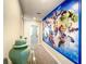 Bright hallway adorned with a superhero mural leading to rooms with neutral decor and ample natural light at 4704 Sleepy Hollow Dr, Kissimmee, FL 34746