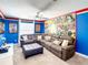 Comfortable living room with a large sectional sofa, comic themed wall art, and bright, colorful accents at 4704 Sleepy Hollow Dr, Kissimmee, FL 34746