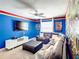 Spacious living room featuring blue walls, a ceiling fan, and a large comfortable sectional sofa at 4704 Sleepy Hollow Dr, Kissimmee, FL 34746