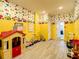 Bright playroom featuring light gray floors, a variety of toys, and cheerful cartoon character wallpaper at 4704 Sleepy Hollow Dr, Kissimmee, FL 34746