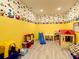 Vibrant playroom with colorful Mickey Mouse themed wallpaper, a playhouse, and various toys at 4704 Sleepy Hollow Dr, Kissimmee, FL 34746