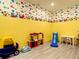 A playroom with cartoon wallpaper, light gray floors and kid friendly toys at 4704 Sleepy Hollow Dr, Kissimmee, FL 34746