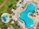 Aerial view of resort-style pool area with lounge chairs and tropical landscaping, perfect for relaxation at 4704 Sleepy Hollow Dr, Kissimmee, FL 34746