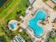 Aerial view of resort-style pool area with lounge chairs and tropical landscaping, perfect for relaxation at 4704 Sleepy Hollow Dr, Kissimmee, FL 34746
