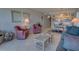 Open living space with pink chairs and view into kitchen with dining area at 5201 S Atlantic Ave # 405A, New Smyrna Beach, FL 32169