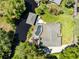 Aerial view of the home features lush landscaping, screened pool, and waterfront boat dock for convenient boating at 5370 Whispering Pine Cir, St Cloud, FL 34771