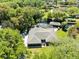 An aerial view of the home shows the screened pool, landscaping, and boat dock on the water at 5370 Whispering Pine Cir, St Cloud, FL 34771