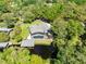 Aerial view of the home shows the screened pool, landscaping, and waterfront boat dock on a sunny day at 5370 Whispering Pine Cir, St Cloud, FL 34771