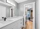 Modern bathroom featuring a gray color scheme, white cabinets and drawers, and a door to the shower at 5370 Whispering Pine Cir, St Cloud, FL 34771