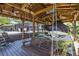 Covered boat dock features a boat lift, ceiling fan, and waterfront access with a porch swing and seating at 5370 Whispering Pine Cir, St Cloud, FL 34771