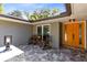 Inviting front porch with rocking chairs and a vibrant orange front door at 5370 Whispering Pine Cir, St Cloud, FL 34771