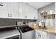 Laundry room with stainless steel washer and dryer, wood countertop, shelves, and white cabinetry at 5370 Whispering Pine Cir, St Cloud, FL 34771