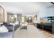 Spacious living room with wood floors, grey couches, and a view of the dining room at 5370 Whispering Pine Cir, St Cloud, FL 34771