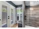 Walk-in shower with a glass enclosure, wood look tiling, a sitting bench, and a door to the outside at 5370 Whispering Pine Cir, St Cloud, FL 34771