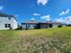 View of the back of the house with blue paint, a screened in patio, and a large backyard at 5526 Bonn Way, St Cloud, FL 34771