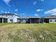 View of the backyard from the side of the yard. The house has a screened in porch at 5526 Bonn Way, St Cloud, FL 34771