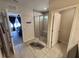 A tiled bathroom has a walk-in shower with seat and a view into the main bedroom at 5526 Bonn Way, St Cloud, FL 34771