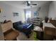 A cozy bedroom with a ceiling fan, artwork, and shelving for personal items is shown at 5526 Bonn Way, St Cloud, FL 34771