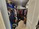 A walk-in closet with shelving and hanging storage, though it needs decluttering and organization to maximize space at 5526 Bonn Way, St Cloud, FL 34771