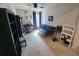 A cozy living room features a futon, desk, shelving and a ceiling fan with natural light, perfect for relaxation and work at 5526 Bonn Way, St Cloud, FL 34771