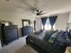 A serene main bedroom is decorated with dark furniture, soft bedding, a ceiling fan, and natural light at 5526 Bonn Way, St Cloud, FL 34771
