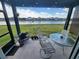 Screened patio includes furniture, a grill, and a view of the pond and houses in the neighborhood at 5526 Bonn Way, St Cloud, FL 34771