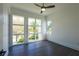 Bright bedroom featuring dark hardwood floors, a ceiling fan, and three large windows at 6106 Marleon Dr, Windermere, FL 34786