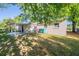 View of the backyard with a covered patio area, grass, and exterior of home with window and trash bins at 616 Conroy St, Orlando, FL 32805