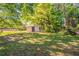 Large backyard with small storage shed surrounded by mature trees, providing ample space and greenery at 616 Conroy St, Orlando, FL 32805