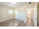 Bedroom with wood-look flooring, neutral walls, and a glimpse into the adjoining bathroom at 616 Conroy St, Orlando, FL 32805